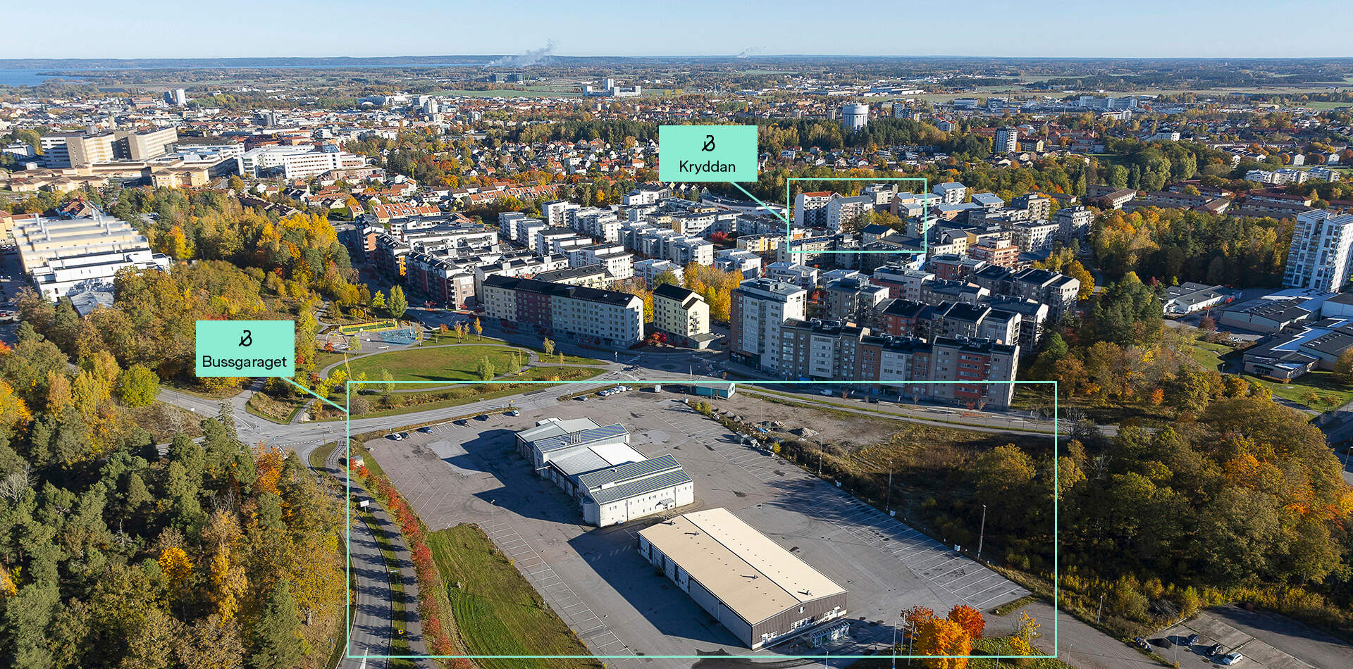 Foto - Nyproduktion i Södra Ekkällan - Flygfoto över ett stadsområde i höstfärger. Två planerade områden markerade: Kvarteret Kryddan och Bussgaraget.