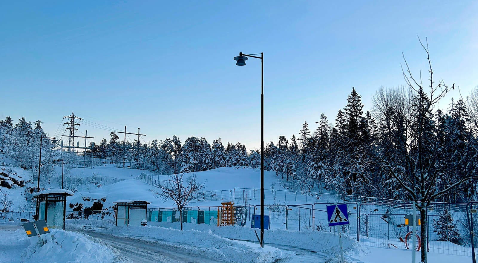 Tollare i full vinterskrud där kommande arbetsområde nu är inhägnat för allas säkerhet