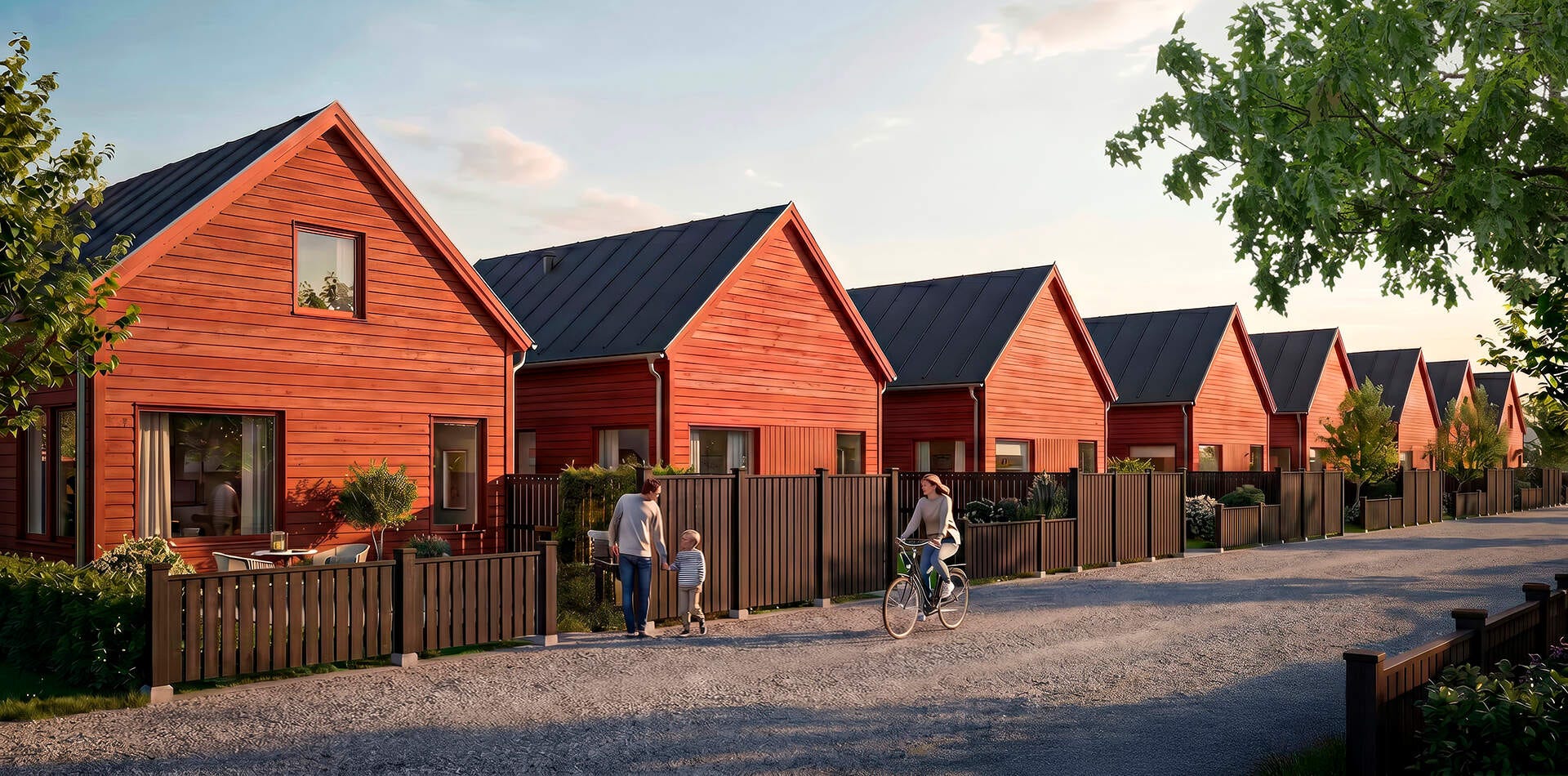 Visualisering - Nyproduktion i Ekängen - Rad med röda trähus med svarta tak längs grusväg, inhägnade uteplatser och personer som promenerar och cyklar.