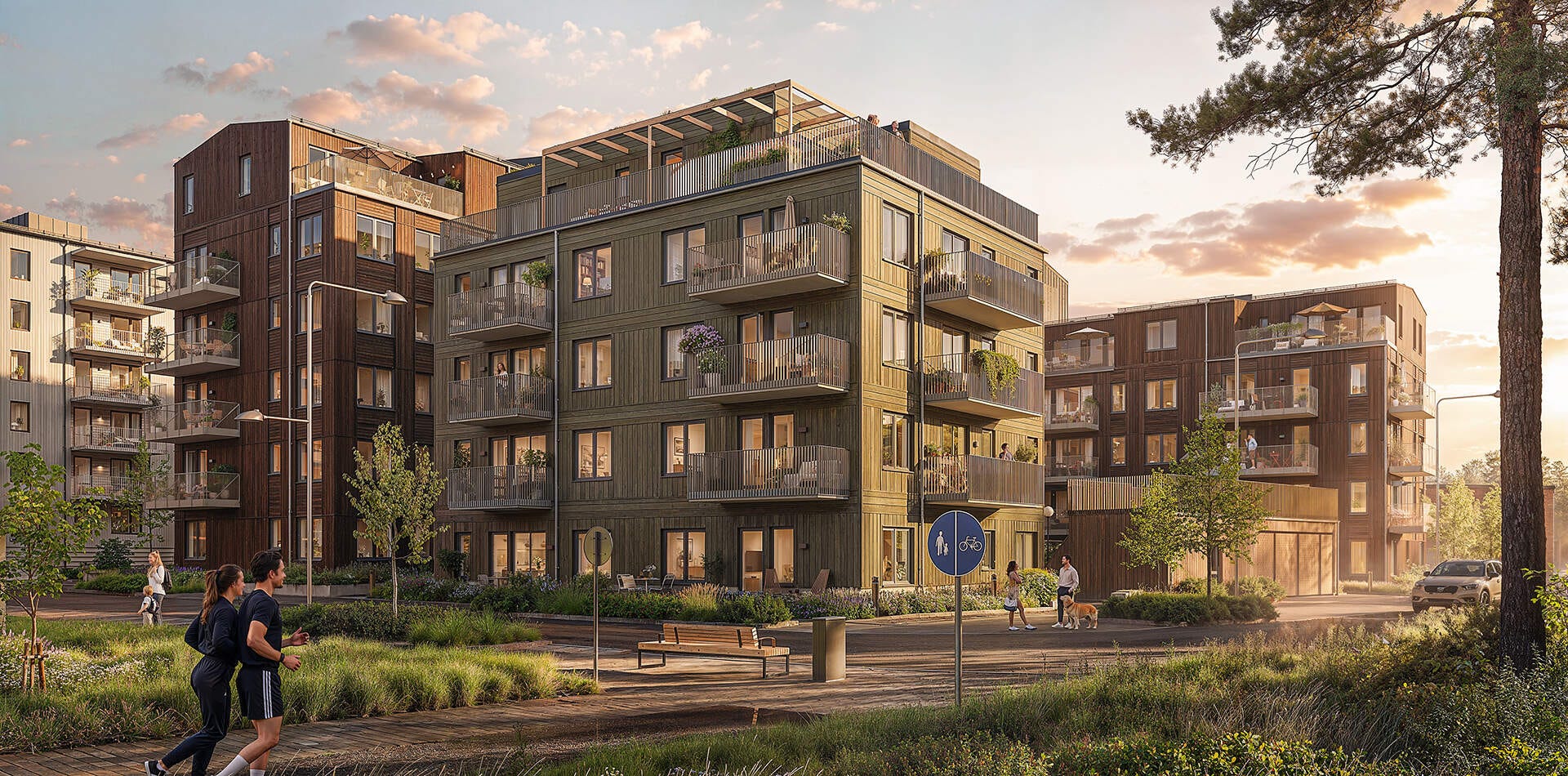 Nyproduktion i Rosendal - Flerbostadshus med balkonger i grön gårdsmiljö vid solnedgång. Personer promenerar och joggar på gångväg framför huset. (Visualisering)