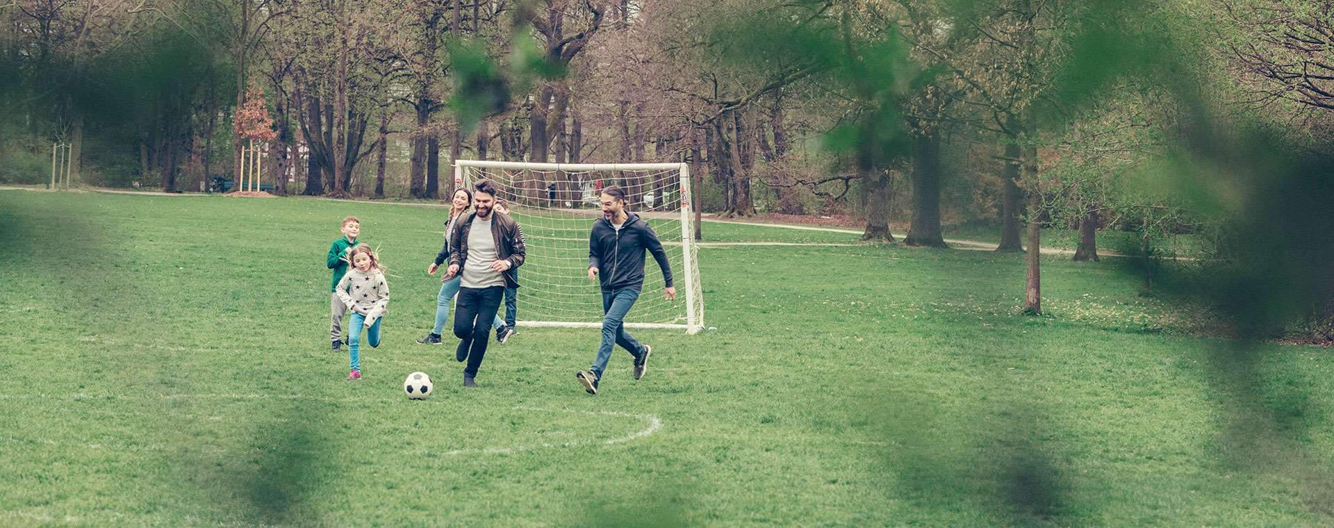 Vänner & barn spelar fotboll tillsammans